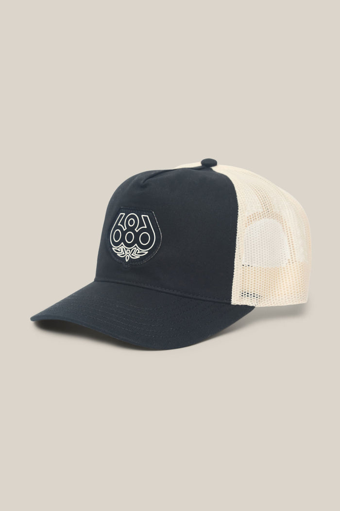 The 686 Mid-Pro Wreath Unstructured 5 Panel Mesh Hat by 686 is a men's black and white trucker hat made from a comfortable polyester cotton blend. It features a curved bill and a distinctive white geometric design on the front, blending everyday style with breathable mesh for all-day comfort.