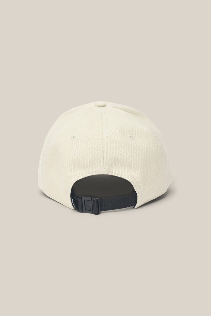 The 686 Low-Pro Unwork Unstructured 6 Panel Hat by 686 is displayed from the back, showcasing its beige polyester cotton construction, black adjustable strap, and metal clasp against a plain light background.