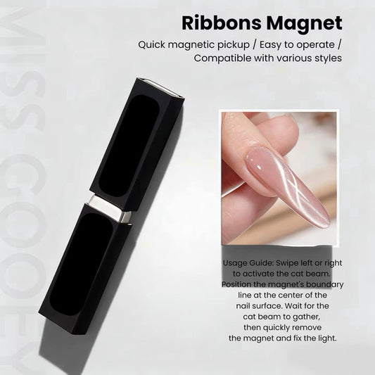 Black ribbons magnet with nail art application on a light gray background
