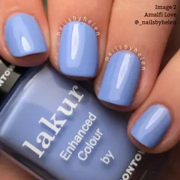 A hand with short, rounded nails painted in a glossy cool blue periwinkle shade of "Amalfi Love" by LONDONTOWN.