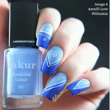 Hand with long nails painted in a cool blue gradient with white geometric designs, holding LONDONTOWN’s Amalfi Love nail polish—a light purple polish perfect for effortless beach vibes.