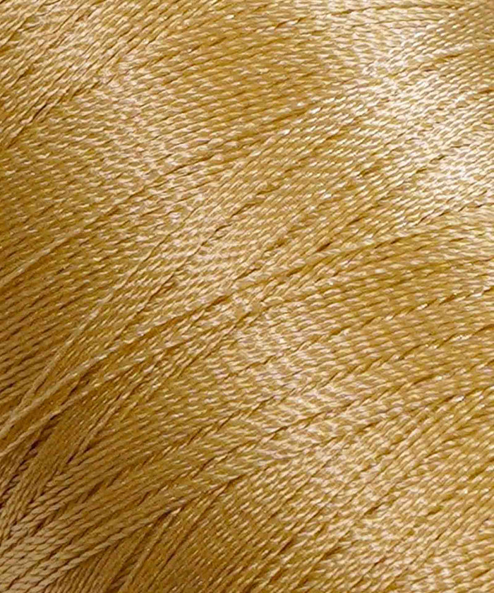 Close-up of lustrous, tightly wound golden-yellow yarn, showing its smooth texture and fine strands.