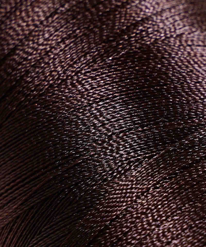 Tightly wound, shiny dark brown thread reveals intricate texture and fine strands, highlighting the rich detail of the material.