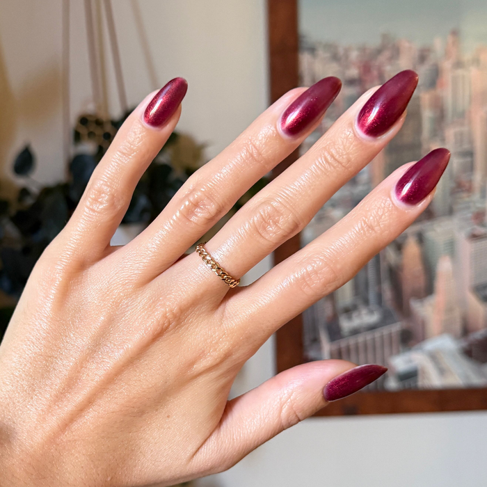 Budget? What Budget Gel deep rose-orange duochrome gel polish on almond-shaped nails for a sleek manicure by Olive and June