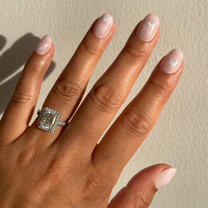 Hand with Butterfly Party | Round | Extra Short press-on nails in pale pink with subtle white butterfly accents for a delicate mani