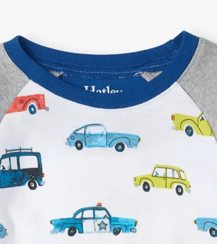 Closeup of Hatley boys car pajama top showing navy neckline and colorful vehicle print.