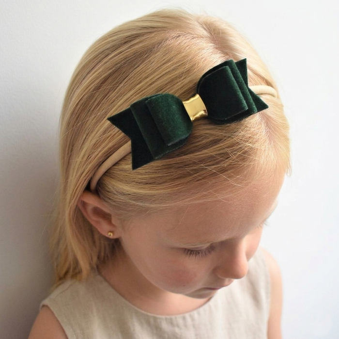 Youn girl wearing a green velvet bow headband