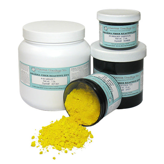 Dharma Trading Fiber Reactive Dye in black jars with blue labels, yellow dye pigment tumbling out on a white background.