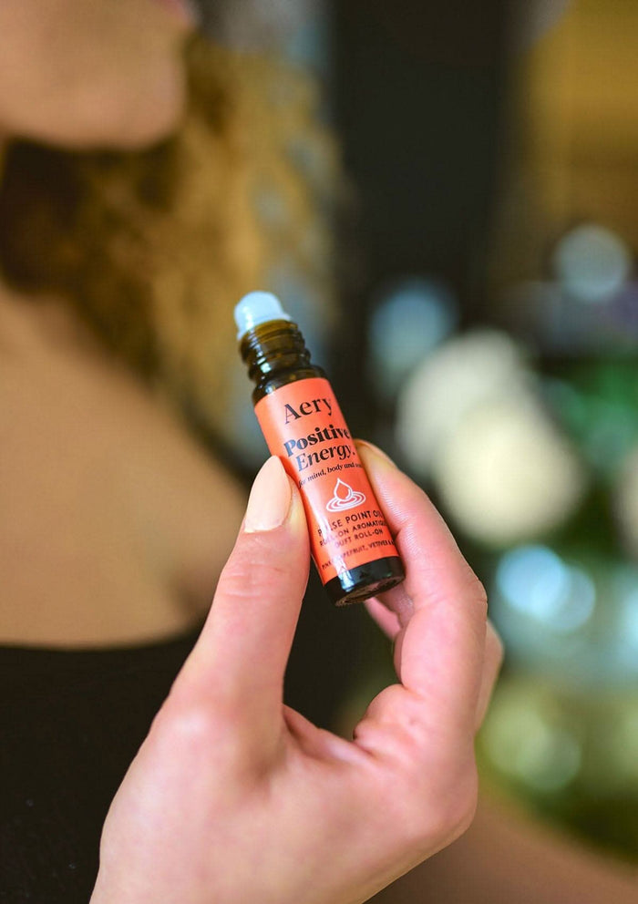 Red positive energy pulse point oil held in hand