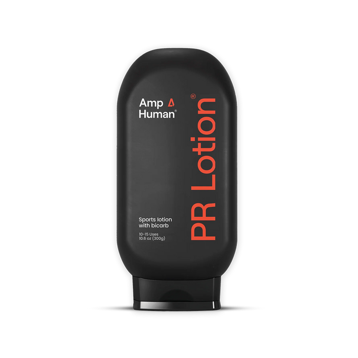 Black bottle of PR Lotion by Amp Human on a black background. Label reads: “Amp Human®,” “PR Lotion®,” “Sports lotion with bicarb,” and “10–15 Uses 10.6 oz (300g).”