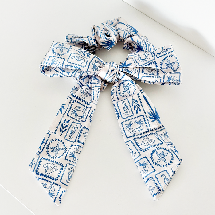 Blue and white satin scrunchie with a large decorative bow.