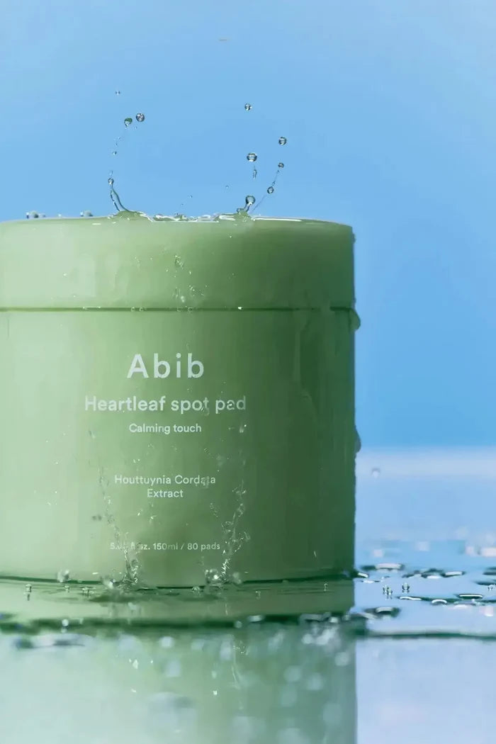 A single instant cool relief pad held by tweezers, showcasing its thin, hydrating texture for soothing skin.