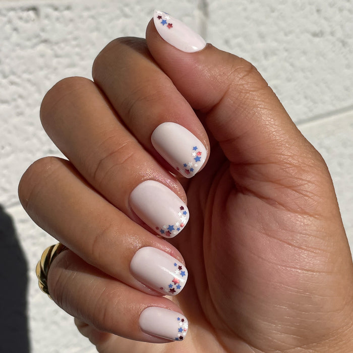 Star Showers | Squoval | Extra Short press-on manicure with extra short squoval nails and tiny festive star French tips design