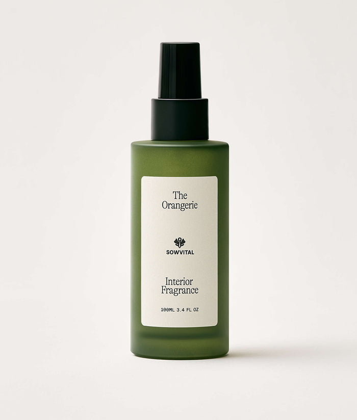Green bottle of interior fragrance with a label on a white background