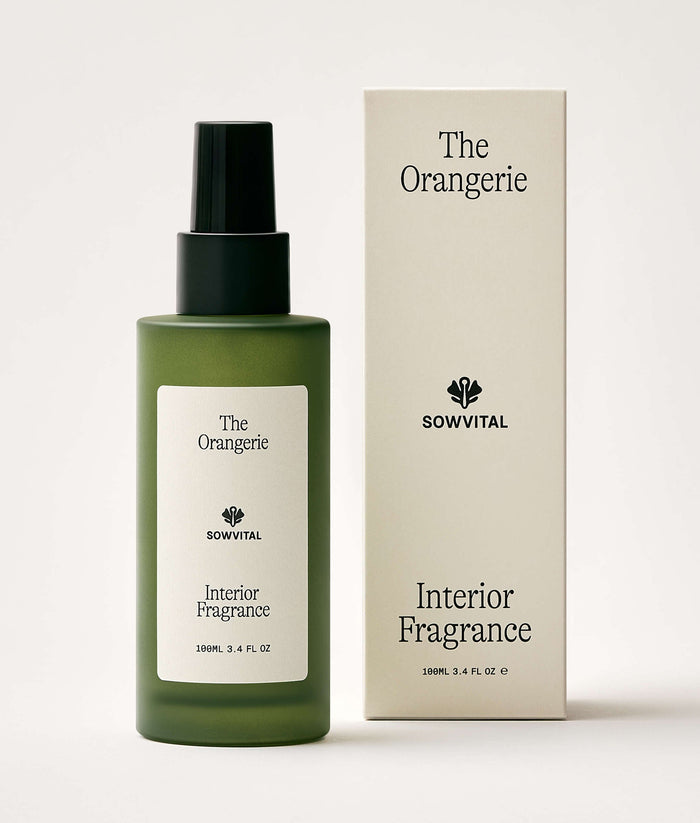 Green interior fragrance bottle and packaging with 'The Orangerie' branding on a white background
