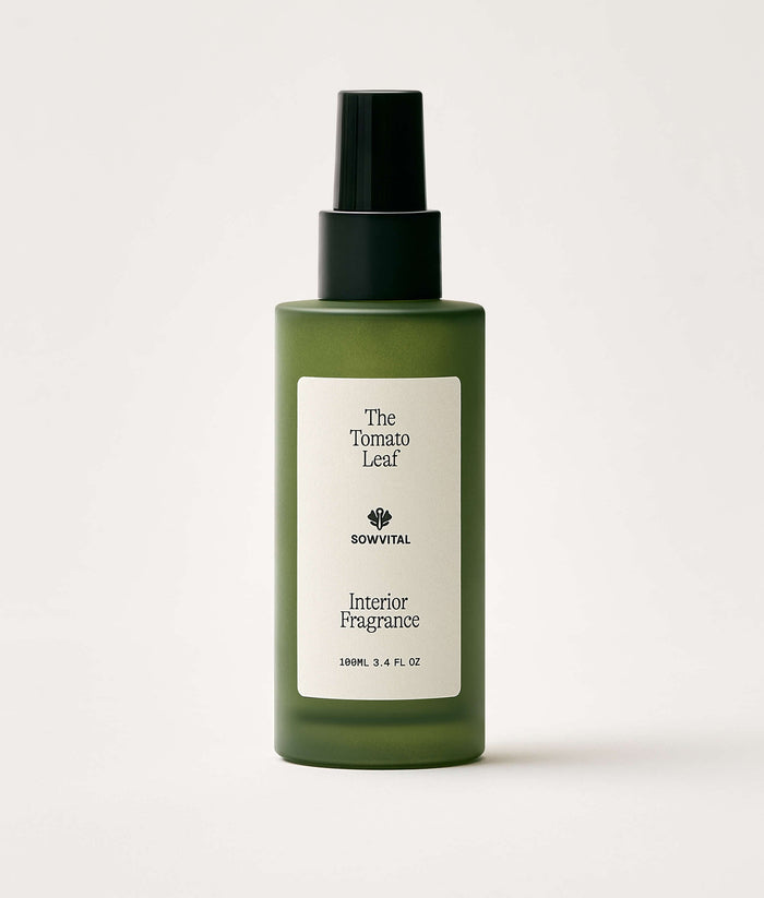 Green bottle of interior fragrance with a label on a white background