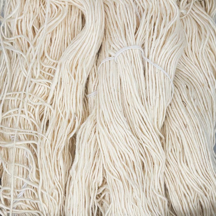 Close up of off-white yarn showing fiber and size of strand.